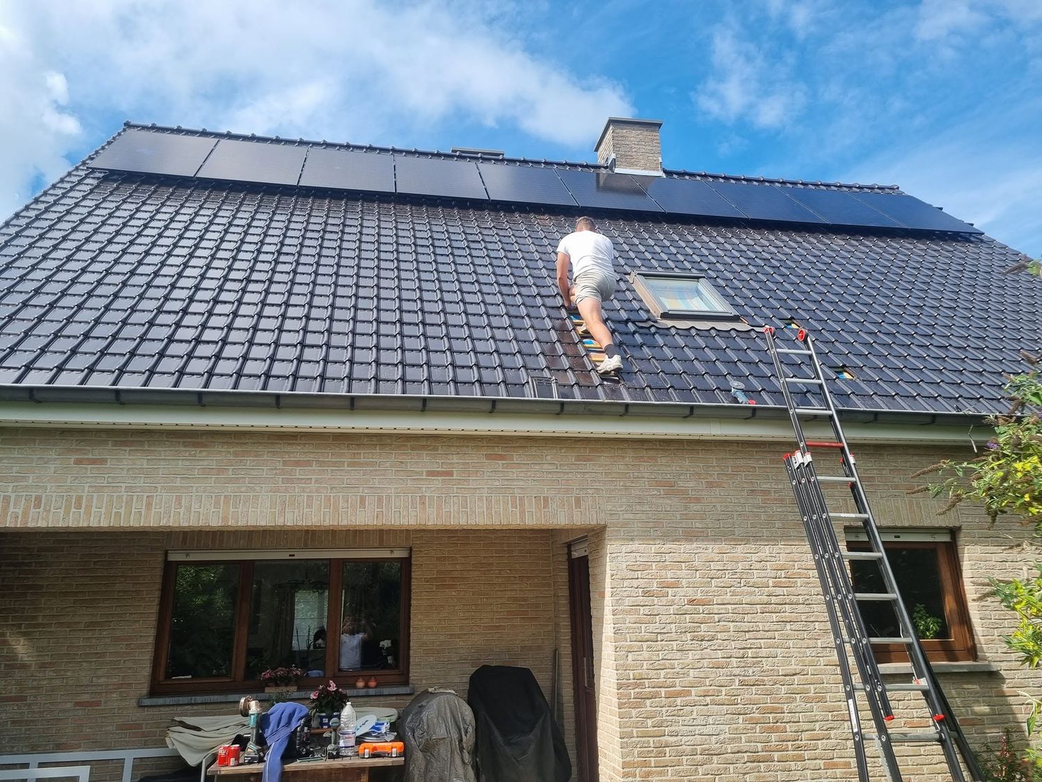 Dakwerker vervangt dakpannen op een pannendak met zonnepanelen