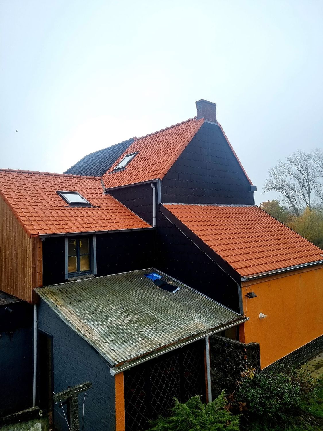Woning met een nieuw rood pannendak, dakvensters en leien gevelbekleding