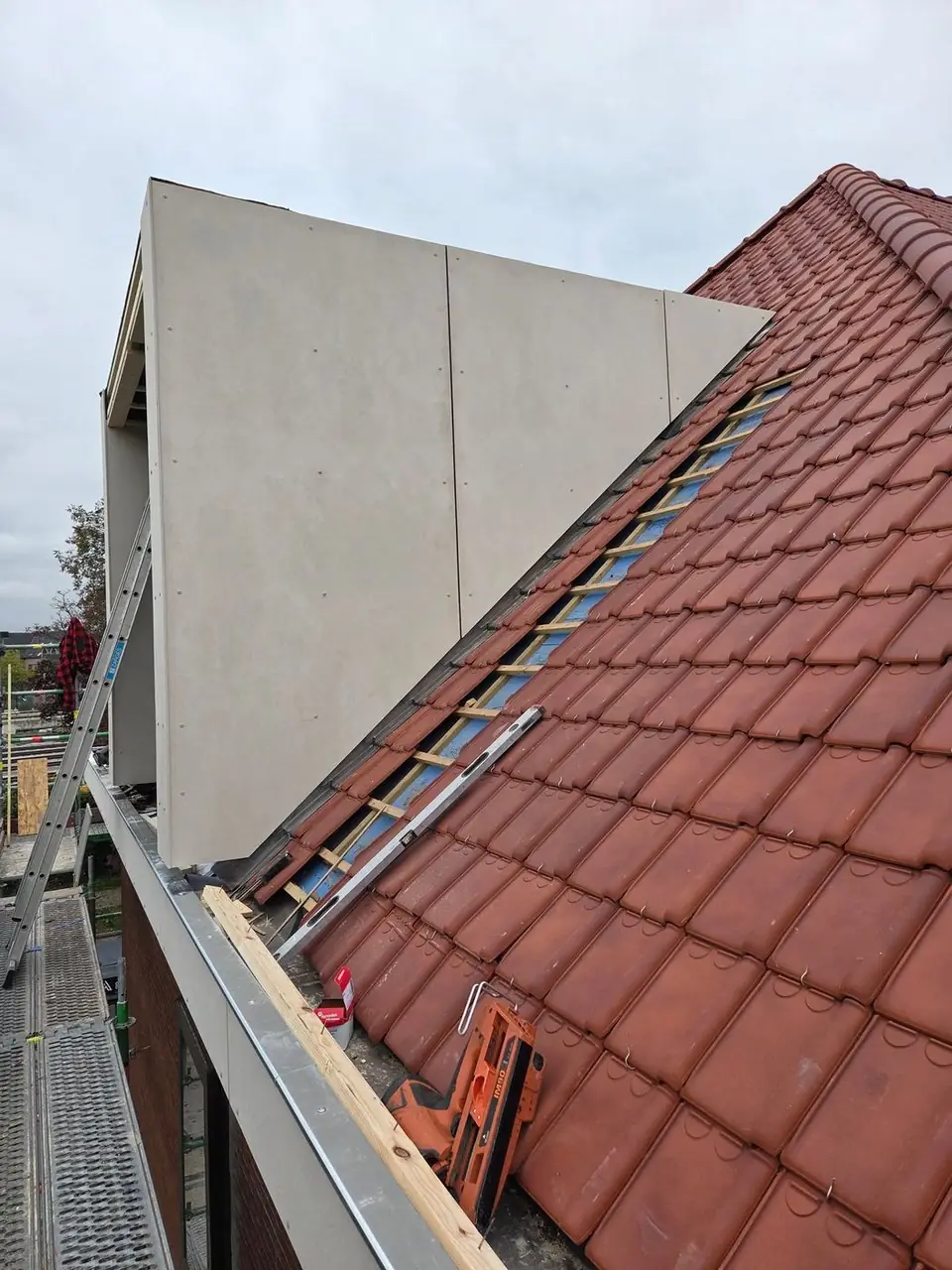 Dakkapel bekleed met gevelplaten, aansluiting op de pannen