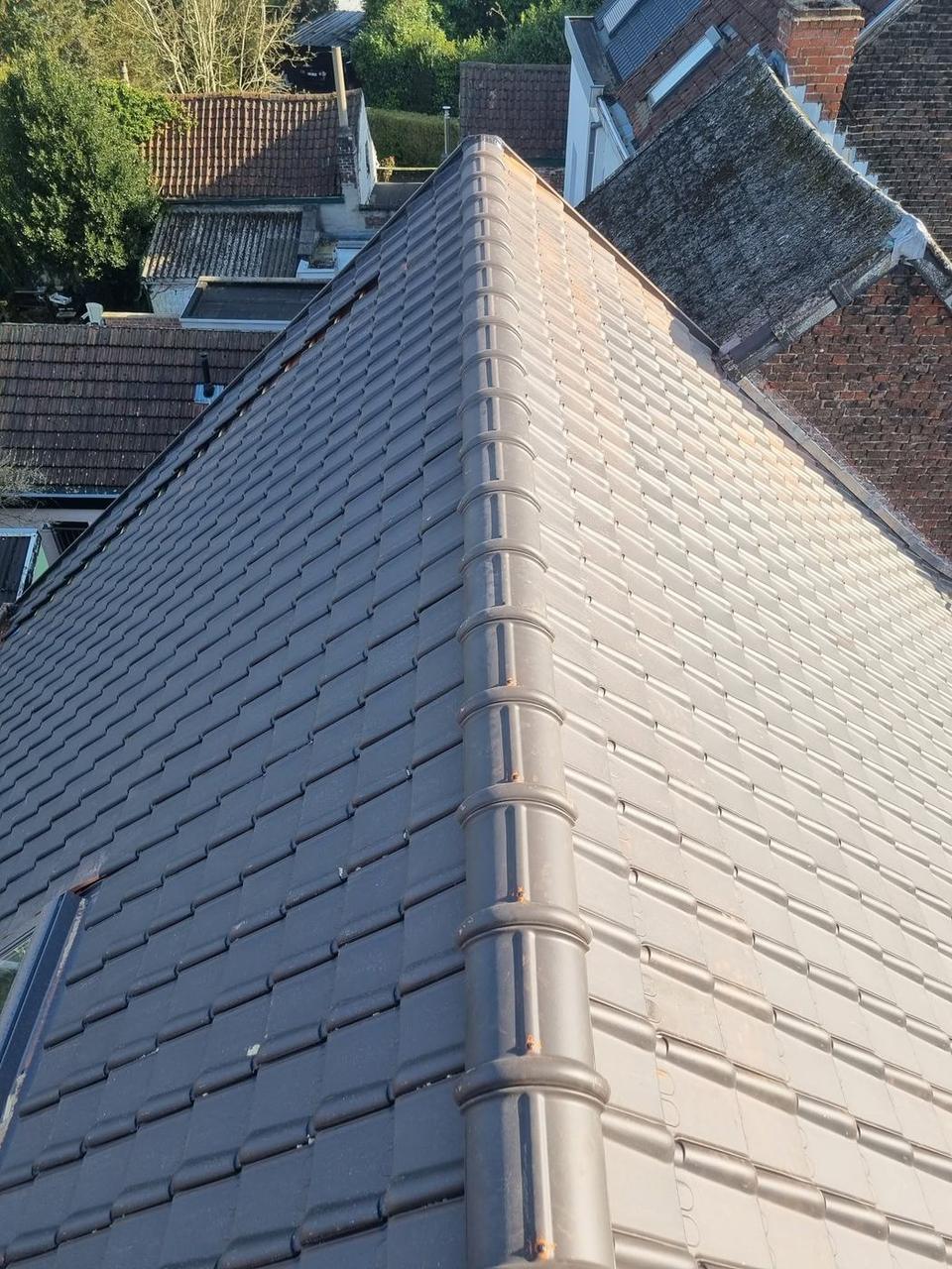 Afgewerkt dak met grijze keramische pannen en nokvorsten