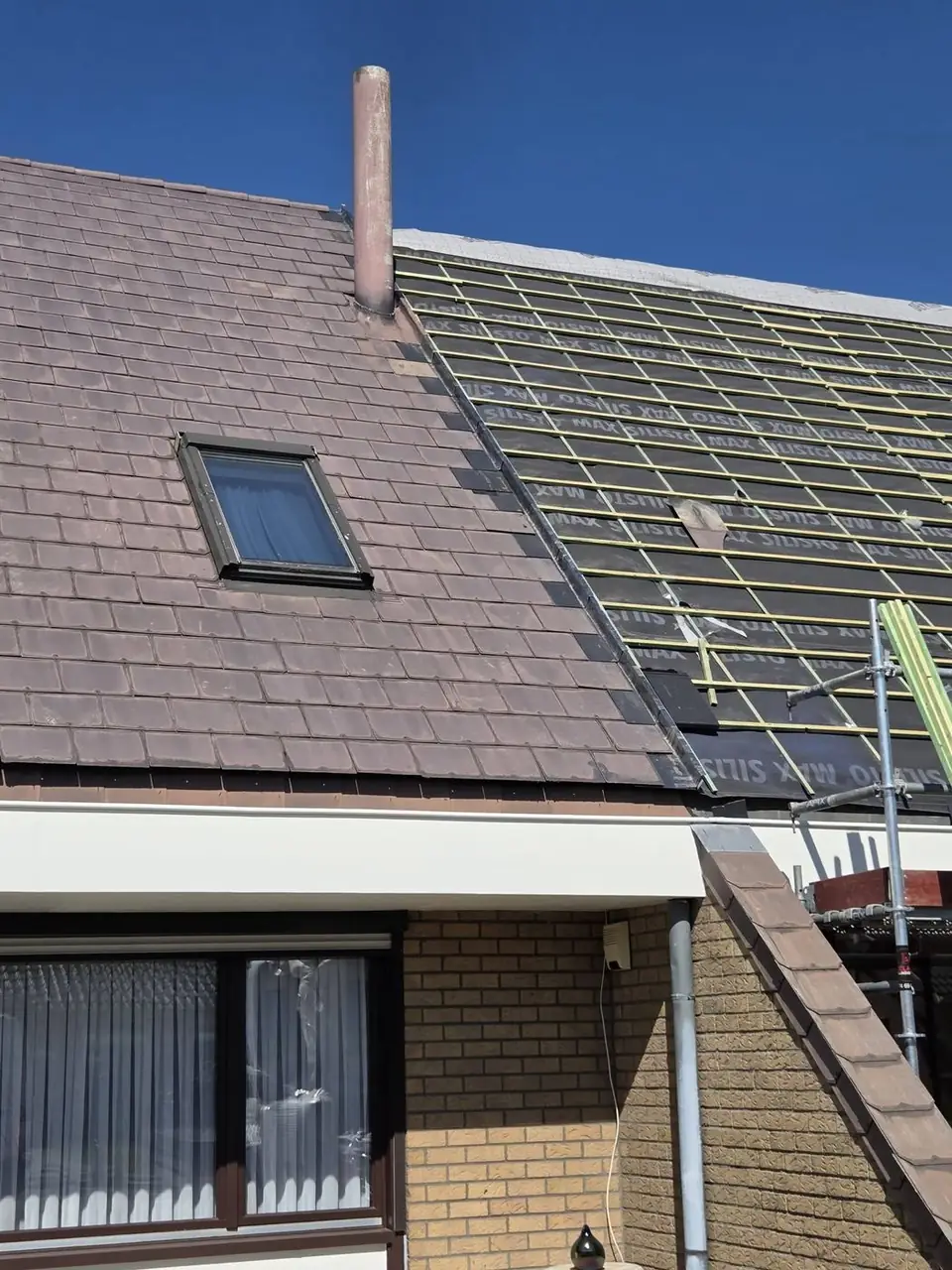 Nieuw onderdak en panlatten naast het oude dak van de buren