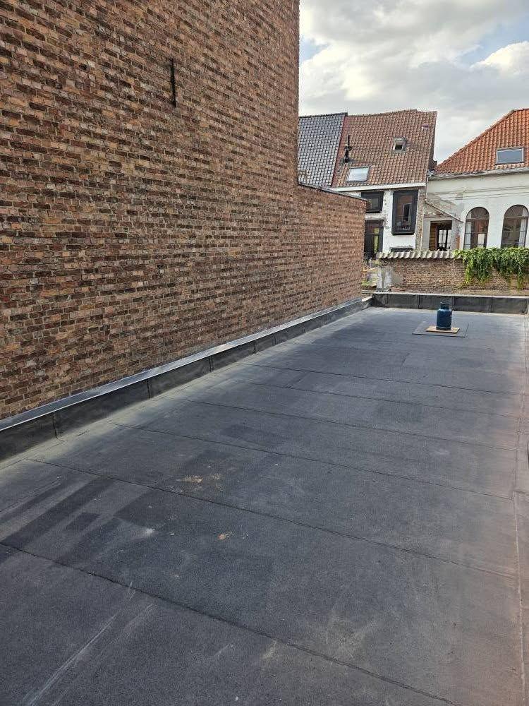 Afgewerkt plat dak tussen de gemene muren