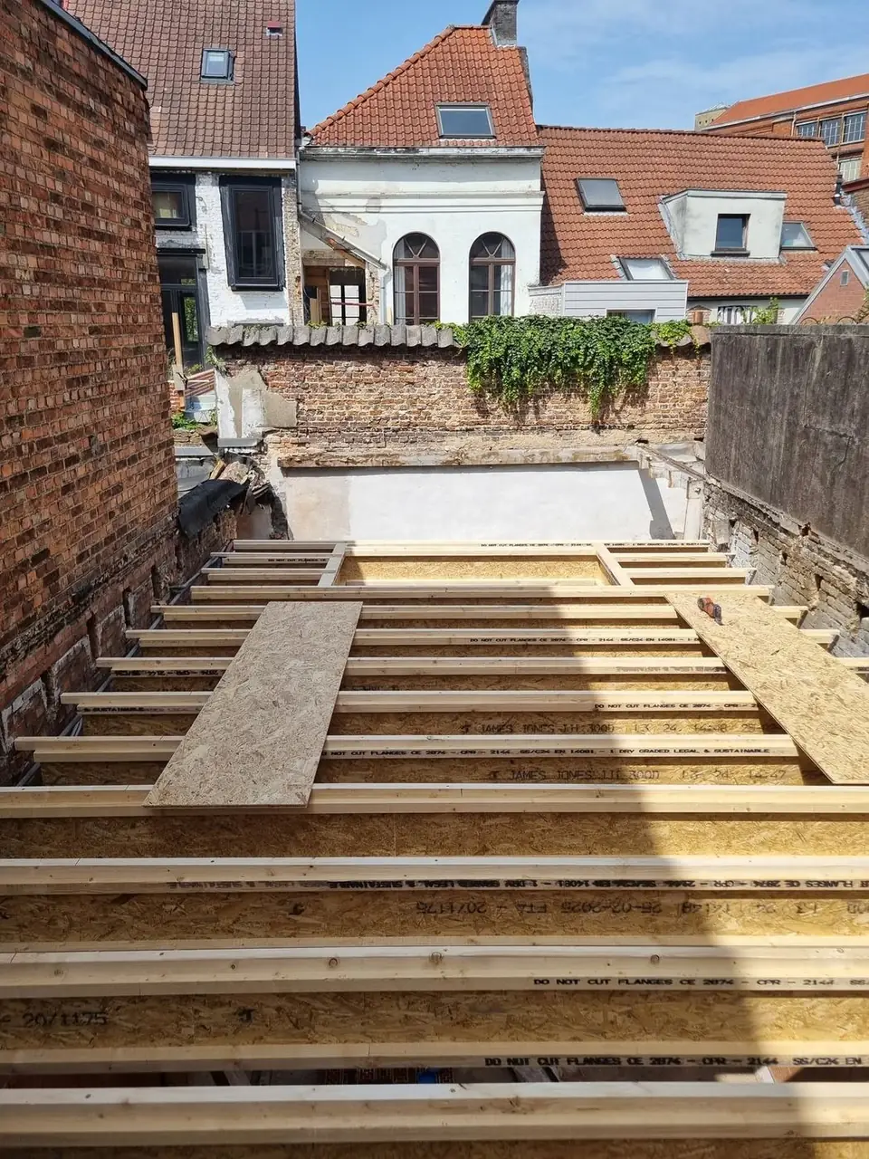 Dakvloer in opbouw, met zicht op de achterliggende woningen