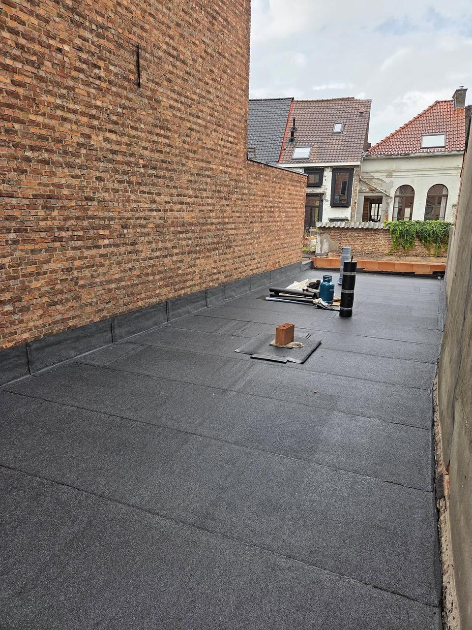 Afgewerkt plat dak met zicht op de achterliggende woningen